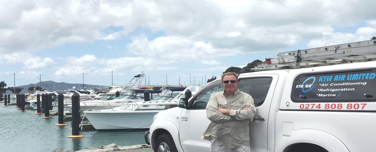 Jon Kyle, air conditioning specialist with Kyle Air work truck at marina